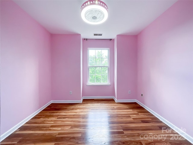 spare room featuring wood finished floors and baseboards