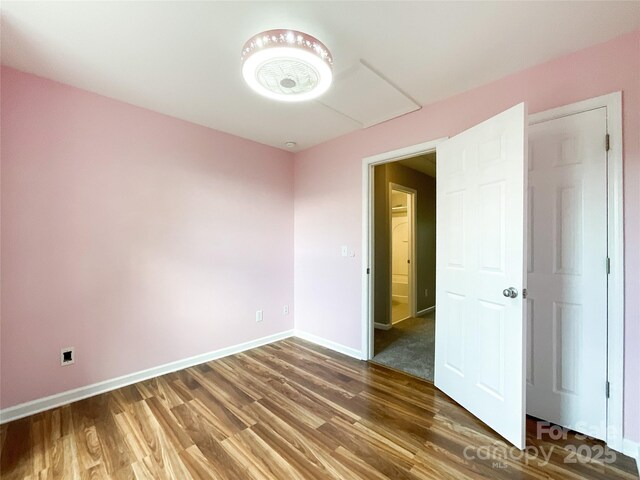 unfurnished room with wood finished floors and baseboards