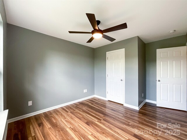 unfurnished bedroom with wood finished floors, baseboards, and ceiling fan