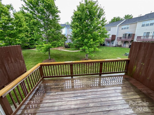 wooden deck featuring a lawn and a residential view