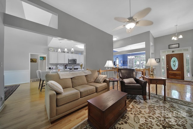 160 Fernbrook Dr, Mooresville, NC 28117 - living room featuring high vaulted ceiling, a chandelier, light wood finished floors, ceiling fan, and wainscoting