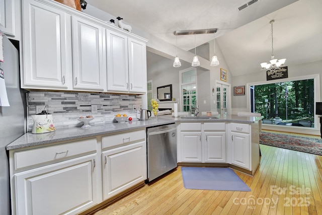 160 Fernbrook Dr, Mooresville, NC 28117 - kitchen with stainless steel dishwasher, lofted ceiling, light wood-type flooring, tasteful backsplash, and white cabinets