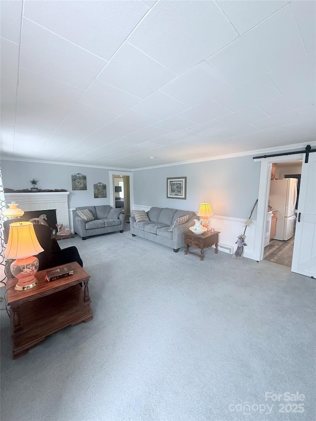 carpeted living room featuring ornamental molding and a barn door
