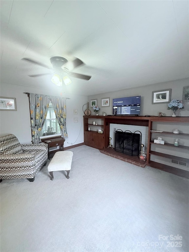 living area featuring a ceiling fan, carpet, and a fireplace