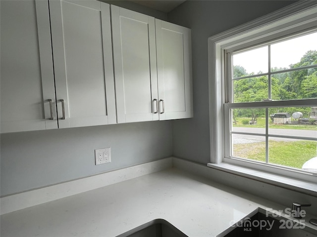 kitchen with light stone countertops and white cabinets