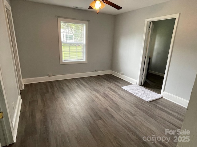 unfurnished bedroom with dark wood-style flooring, baseboards, and ceiling fan