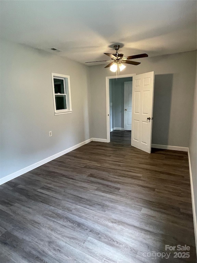 unfurnished bedroom featuring ceiling fan, baseboards, visible vents, and dark wood finished floors