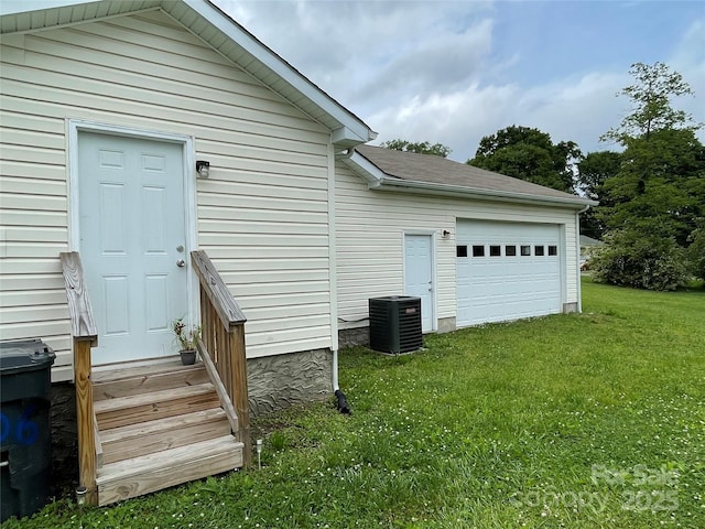 exterior space with central AC unit, entry steps, and a lawn