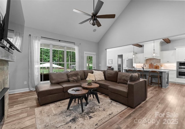 2646 Lee Lawing Rd, Lincolnton, NC 28092 - living room featuring a brick fireplace, high vaulted ceiling, ceiling fan, and light wood-style flooring