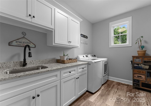 2646 Lee Lawing Rd, Lincolnton, NC 28092 - clothes washing area with cabinet space, washing machine and clothes dryer, wood finished floors, and baseboards