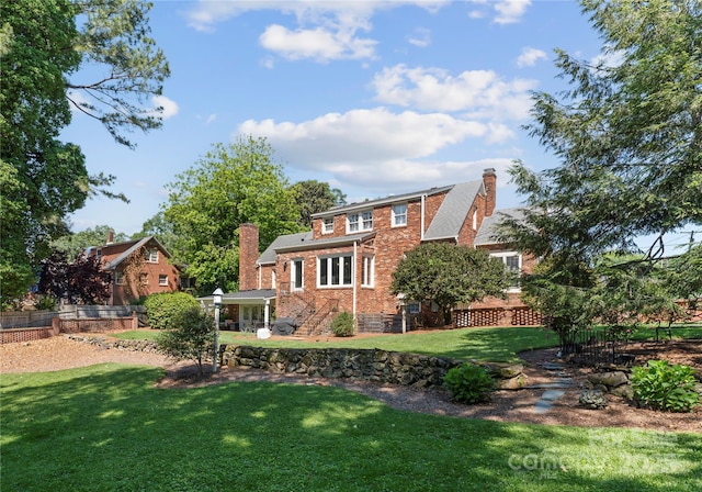 rear view of property with brick siding and a chimney