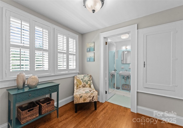 sitting room featuring plenty of natural light, light wood finished floors, and baseboards