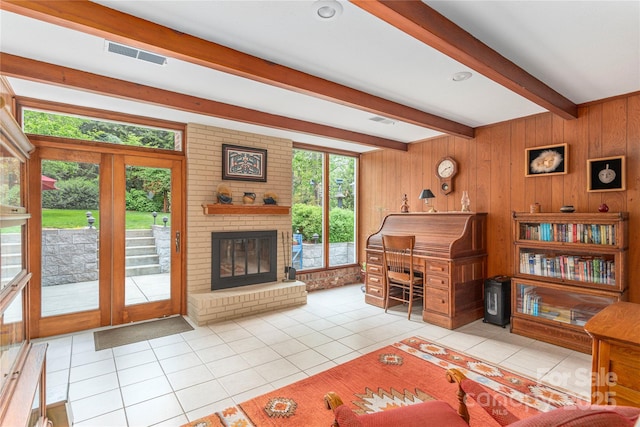tiled living room featuring wood walls, visible vents, and beam ceiling