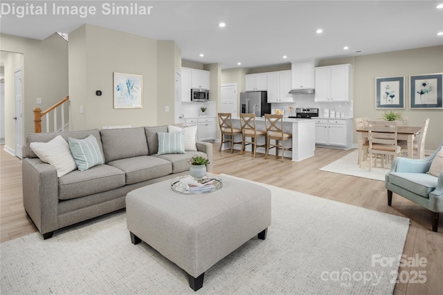 living area featuring recessed lighting, stairway, and light wood-style floors