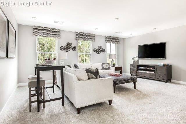 carpeted living area featuring baseboards