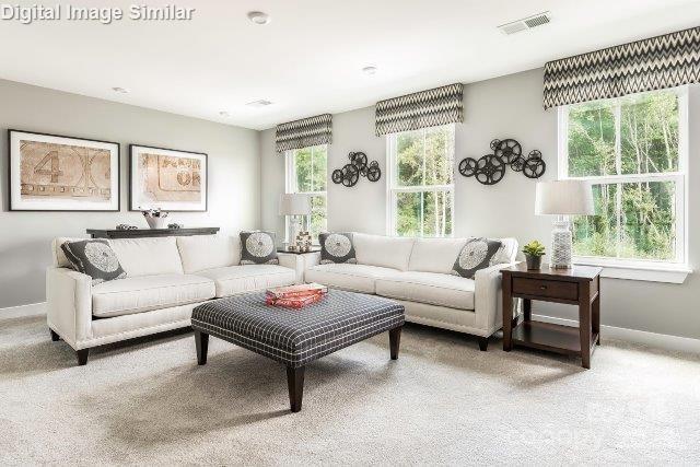 living room featuring carpet flooring, baseboards, and visible vents