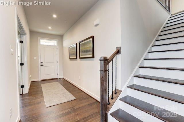 foyer featuring baseboards, recessed lighting, wood finished floors, and stairs