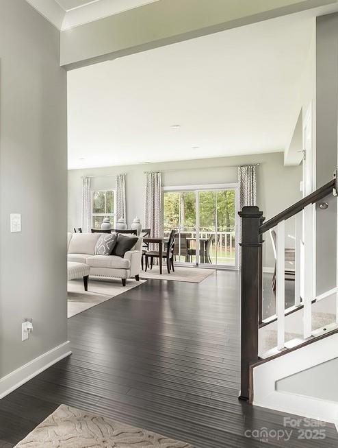 interior space with baseboards, stairs, wood finished floors, and a wealth of natural light