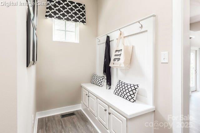mudroom featuring baseboards, visible vents, and wood finished floors