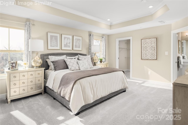 bedroom with visible vents, crown molding, light colored carpet, baseboards, and a spacious closet