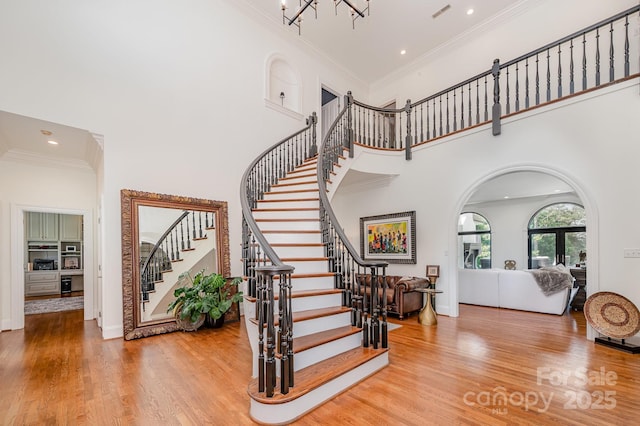 5400 Challisford Ln, Charlotte, NC 28226 - stairway featuring crown molding, visible vents, a towering ceiling, and wood finished floors