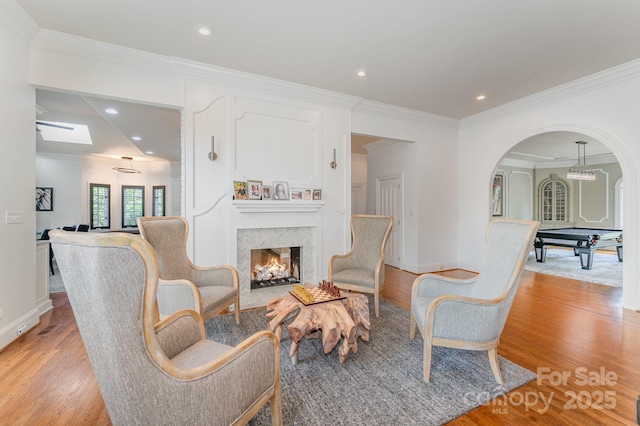 5400 Challisford Ln, Charlotte, NC 28226 - living area featuring baseboards, ornamental molding, a high end fireplace, arched walkways, and light wood-type flooring
