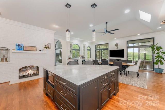5400 Challisford Ln, Charlotte, NC 28226 - kitchen featuring a brick fireplace, a healthy amount of sunlight, and light wood-style flooring