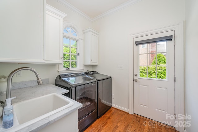 5400 Challisford Ln, Charlotte, NC 28226 - washroom with a sink, cabinet space, washing machine and clothes dryer, crown molding, and light wood-type flooring