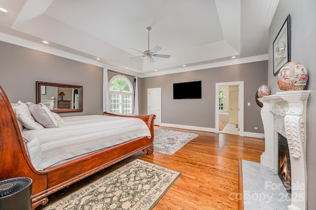 5400 Challisford Ln, Charlotte, NC 28226 - bedroom featuring wood finished floors, recessed lighting, crown molding, a tray ceiling, and a tiled fireplace