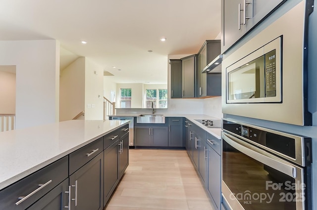 2907 W Trade St, Charlotte, NC 28208 - kitchen with a sink, appliances with stainless steel finishes, recessed lighting, light countertops, and light wood-style floors
