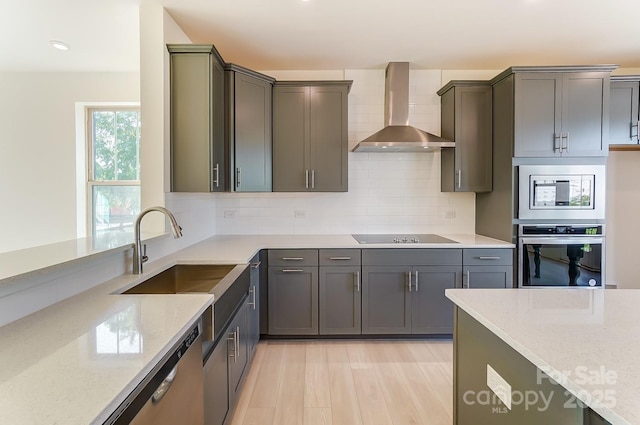 2907 W Trade St, Charlotte, NC 28208 - kitchen with wall chimney exhaust hood, stainless steel appliances, light stone counters, and a sink