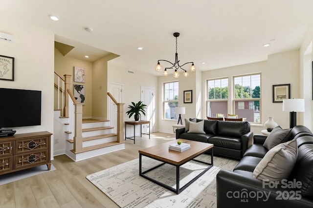 2907 W Trade St, Charlotte, NC 28208 - living room with a chandelier, stairway, light wood-style flooring, and baseboards