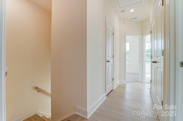 2907 W Trade St, Charlotte, NC 28208 - hallway featuring attic access, baseboards, visible vents, an upstairs landing, and light wood-type flooring