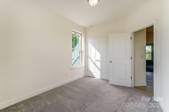2907 W Trade St, Charlotte, NC 28208 - unfurnished bedroom featuring baseboards, a closet, and carpet