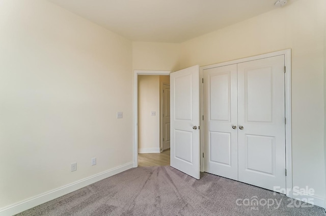 2907 W Trade St, Charlotte, NC 28208 - unfurnished bedroom with a closet, baseboards, and carpet floors