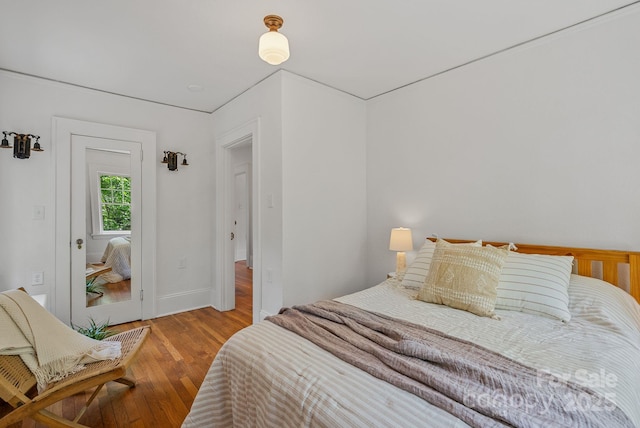 bedroom with baseboards and wood finished floors
