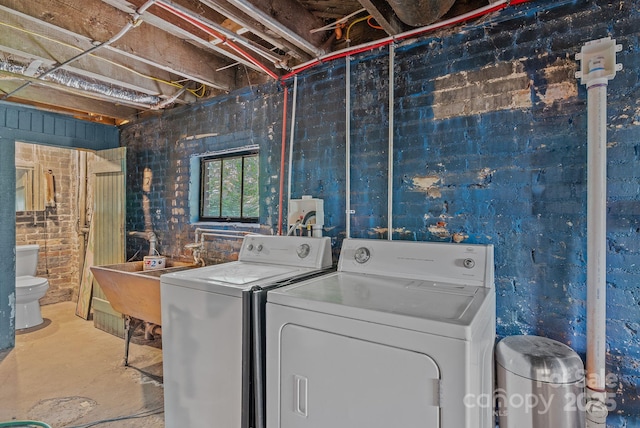 washroom featuring laundry area, independent washer and dryer, and a sink