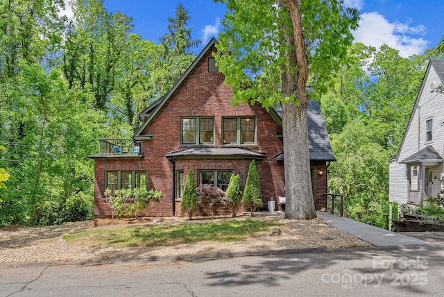 21 Sylvan Ave, Asheville, NC 28801 - english style home with brick siding, a balcony, and a shingled roof