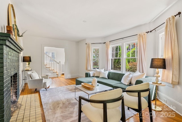 21 Sylvan Ave, Asheville, NC 28801 - living room featuring a brick fireplace, light wood-style flooring, baseboards, and stairs
