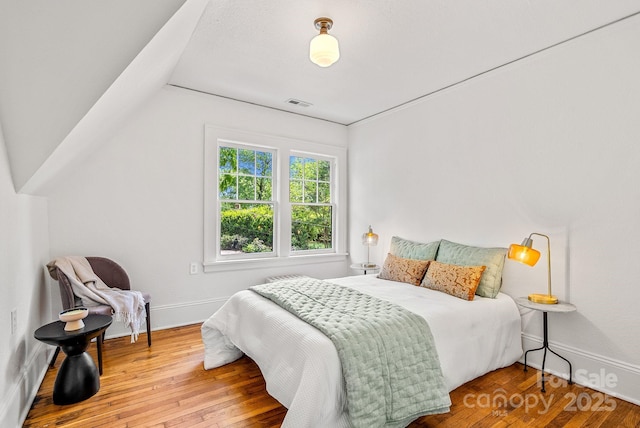 21 Sylvan Ave, Asheville, NC 28801 - bedroom with wood-type flooring, vaulted ceiling, and baseboards