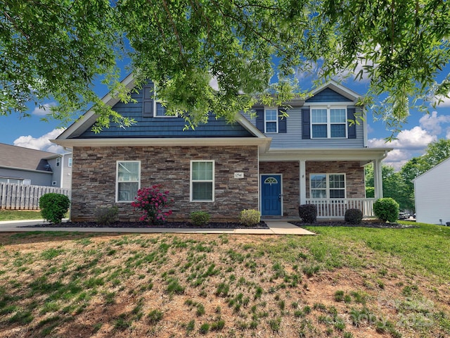 6541 Hasley Woods Dr, Huntersville, NC 28078 - view of front of home with covered porch, a front yard, fence, and stone siding