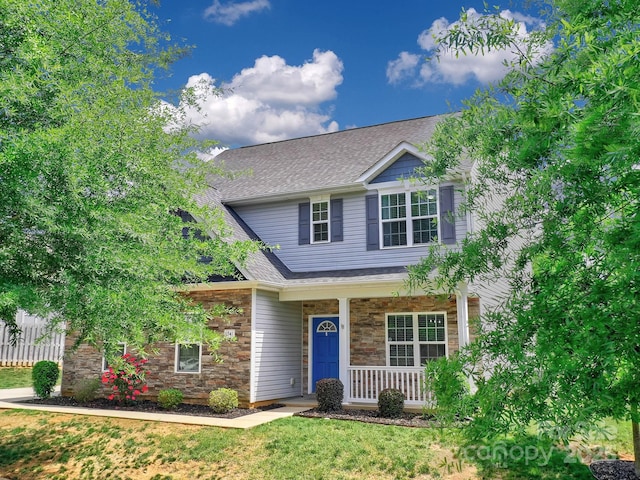 6541 Hasley Woods Dr, Huntersville, NC 28078 - view of front of home featuring a porch, roof with shingles, fence, and stone siding