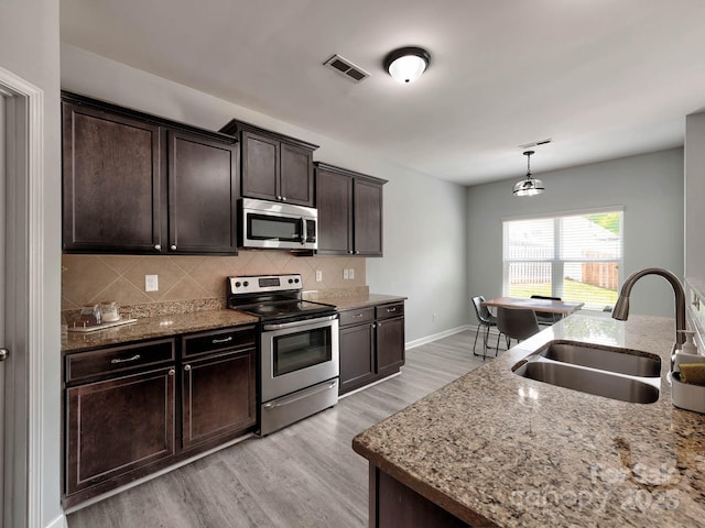6541 Hasley Woods Dr, Huntersville, NC 28078 - kitchen featuring a sink, stainless steel appliances, light wood-type flooring, tasteful backsplash, and visible vents