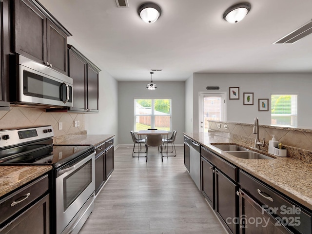 6541 Hasley Woods Dr, Huntersville, NC 28078 - kitchen featuring dark brown cabinetry, appliances with stainless steel finishes, a sink, light wood-type flooring, and backsplash