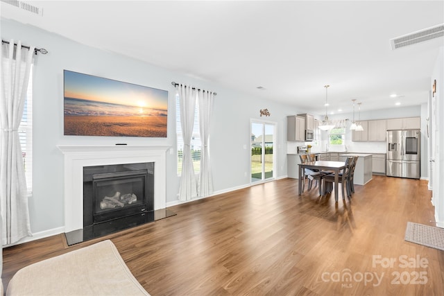 133 W Neel Ranch Rd, Mooresville, NC 28115 - living room with visible vents, recessed lighting, a glass covered fireplace, and wood finished floors