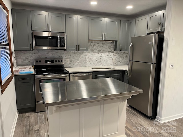 128 Sandsridge Way, Waynesville, NC 28785 - kitchen featuring appliances with stainless steel finishes, light wood finished floors, stainless steel countertops, baseboards, and tasteful backsplash