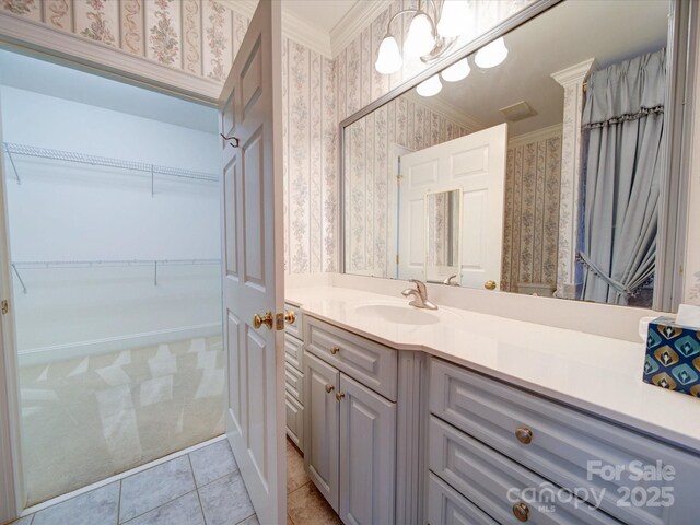 3015 Hamptonbrook Dr, Gastonia, NC 28056 - bathroom with wallpapered walls, crown molding, vanity, tile patterned flooring, and a walk in closet