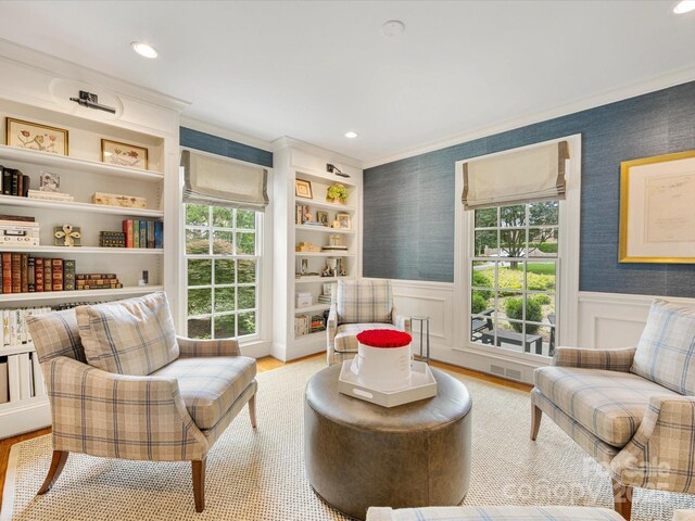 sitting room featuring a wainscoted wall, wood finished floors, recessed lighting, and ornamental molding