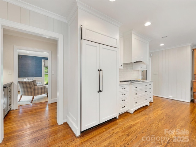 hallway featuring ornamental molding, light wood-type flooring, recessed lighting, and baseboards
