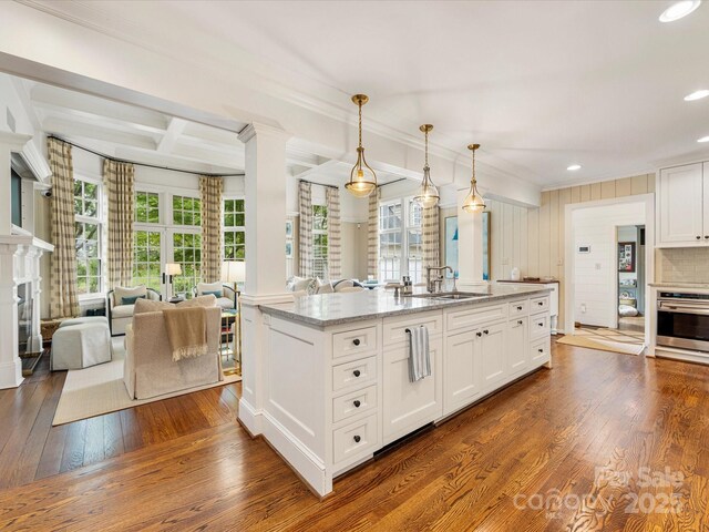 kitchen with oven, a fireplace, crown molding, white cabinetry, and dark wood-style floors